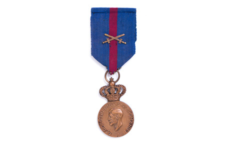 Medalia ”Ferdinand I. Rege al Românilor”, cu spade, cu crucea comemorativă a războiului 1914-1927, acordată lui Delean Valeriu. Decorație, bronz, textil, Ltotală: 11 cm, D: 5 cm. Donație, Aurora Olariu, p.v. nr. 582/26.03.1983.